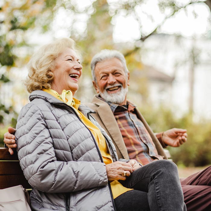 senior couple laughing on bench