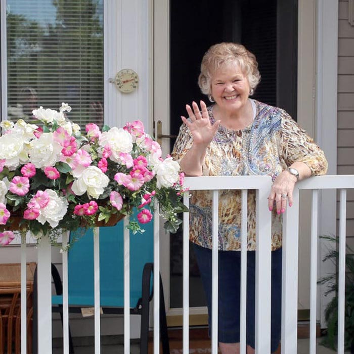 senior woman waving from patio